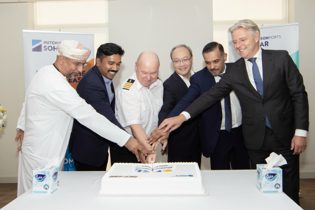 ESL and Hutchison Ports Sohar team cutting a cake to celebrate the milestone of ESL Oman's Maiden Voyage